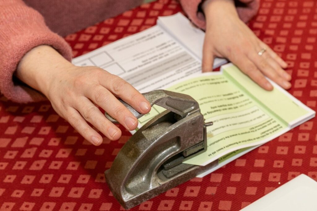 Image of ballot paper being stamped by polling staff member, 